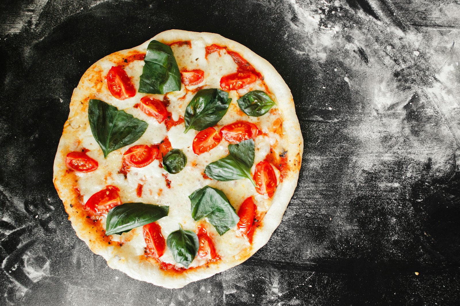 Pizza Margherita recién horneada con albahaca fresca